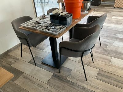 une table avec des chaises et un vase posé dessus dans un salon