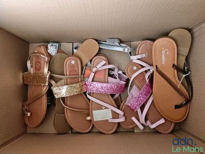 plusieurs paires de sandales dans une boîte en carton posée sur une table
