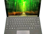 l'ordinateur portable est ouvert sur une surface blanche, avec des arbres verts en arrière-plan