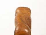 a wooden sculpture of a shoe on a white pedestal