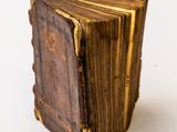 a close up of an old book on a white surface