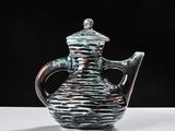 a black and green teapot sitting on a white table