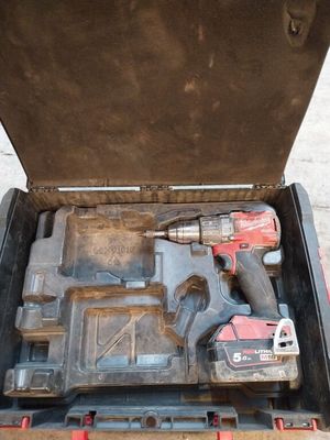 une boîte à outils contenant des outils, posée sur le sol