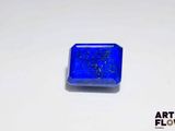 a close up of a blue square shaped stone on a white surface