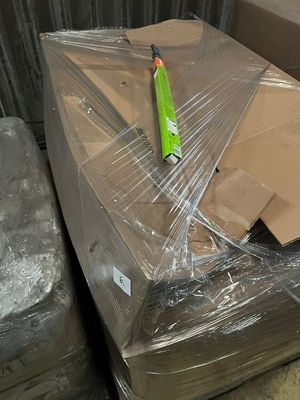 many boxes and boxes wrapped in plastic on the floor