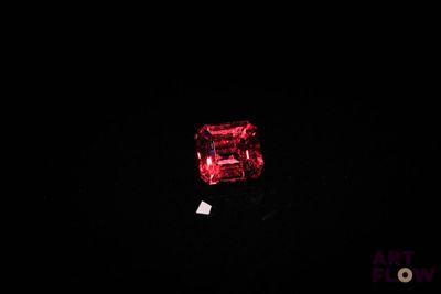 a close up of a red diamond on a black surface