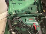 une boîte verte contenant des outils, posée sur le sol
