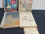 Plusieurs livres pour enfants sont posés sur une table recouverte d'une nappe bleue