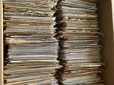 une boîte en carton ouverte, remplie d'une multitude de papiers, posée sur une table