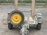 a small trailer with a yellow wheel on the ground