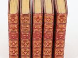 six red books are lined up in a row on a white surface