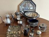 une table en bois sur laquelle sont posés de nombreux objets en argent