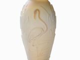 a white vase with a bird on it on a white surface