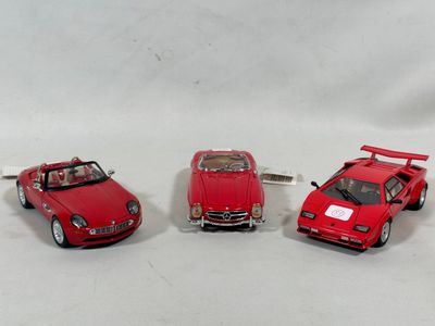 three toy cars sitting next to each other on a white surface