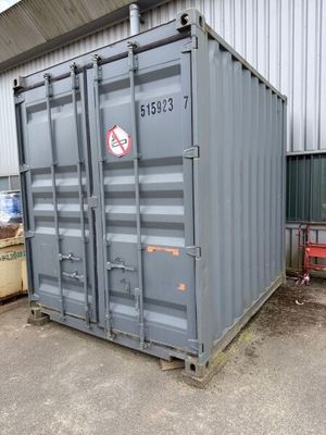 a large gray container sitting in front of a building