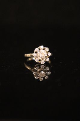 a close up of a diamond ring on a black surface