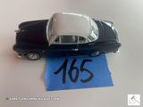 une petite voiture posée sur une feuille de papier