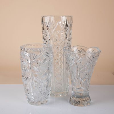 three glass vases sitting on a table next to each other