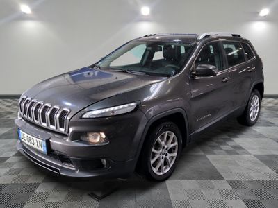 Une jeep grise est garée dans une pièce au sol carrelé
