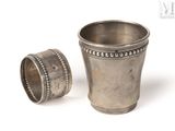 une coupe en argent et une bague en argent sur fond blanc