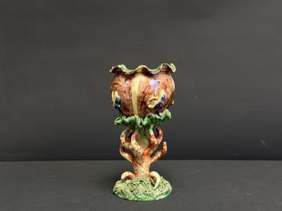 une image représentant un vase orné d'un oiseau, posé sur une table