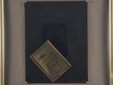 an old picture of a black and gold frame with a piece of paper in it