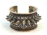 bracelet manchette en argent orné de pointes et de rivets sur fond blanc