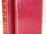 two red books sitting next to each other on a white surface