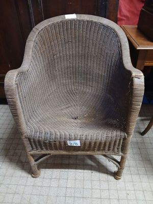 a wicker chair that is sitting on a tile floor