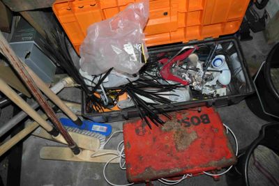 une boîte à outils remplie d'objets divers dans un garage