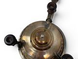 a silver tea pot with a wooden handle on a white surface