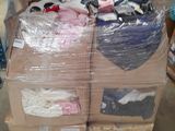 Des cartons de vêtements sont empilés les uns sur les autres dans un entrepôt