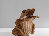 un petit sac en rotin avec un lézard à l'intérieur