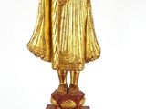 statue en or représentant une personne tenant un enfant dans ses bras, posée sur un socle en marbre