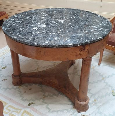 une table au plateau en marbre posée sur un tapis dans un salon