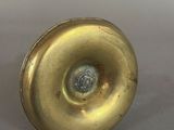 a small brass object on a white surface