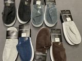 Plusieurs paires de pantoufles pour homme sont exposées dans un magasin
