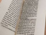 a person holding a book open on a table