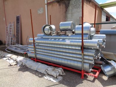 a large pile of pipes sitting outside of a building