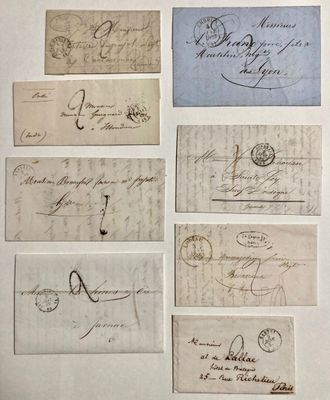 plusieurs vieux morceaux de papier couverts d'écriture, posés sur une table