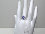 une main sur laquelle est passée une bague sertie d'une pierre bleue