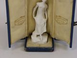 a figurine of a woman standing in a case