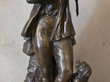 statue en bronze représentant un garçon avec un chien, posée sur un socle en marbre