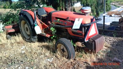 a red tractor that is sitting in the grass
