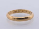 a close up of a gold ring on a white surface