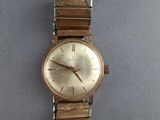 an image of a gold wrist watch on a gray surface