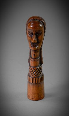 un gros plan sur une sculpture en bois représentant la tête d'une femme