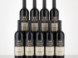 six bottles of red wine are lined up on a table