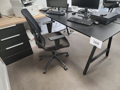 a desk with two computers and a keyboard on it