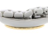 underside view of a white computer mouse on a gold plate